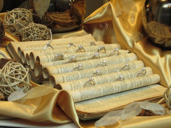 Decoración de un escaparate de joyería con anillos en libros