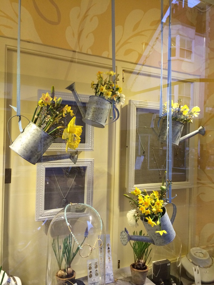 Decoración de un escaparate de joyería con macetas de flores