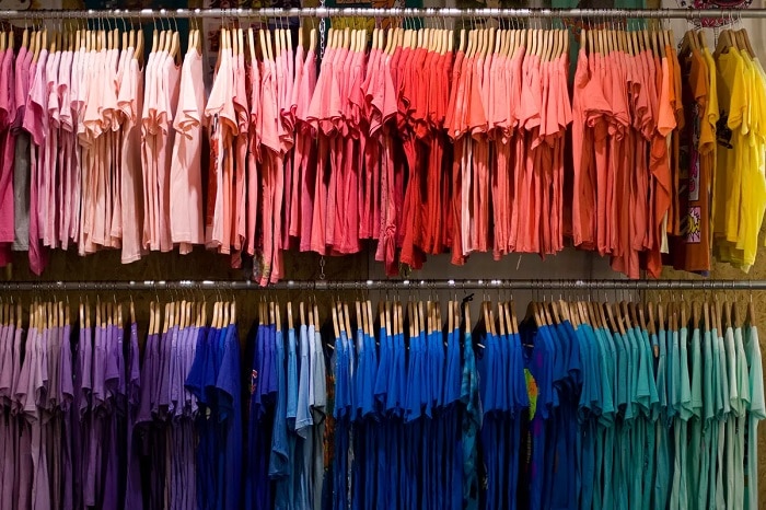 Tienda de ropa con camisetas organizada por colores